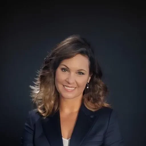 A woman in a suit smiling for the camera.